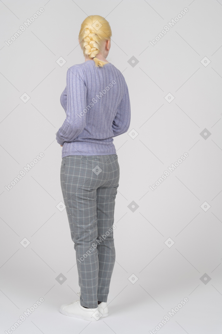 Vista posteriore di tre quarti di una donna in abiti casual che distoglie lo sguardo