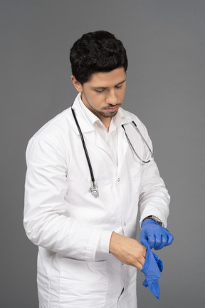 Doctor taking off gloves