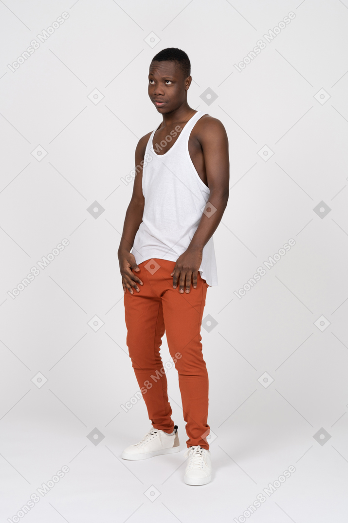 Athletic young man standing with hands on thighs and looking up