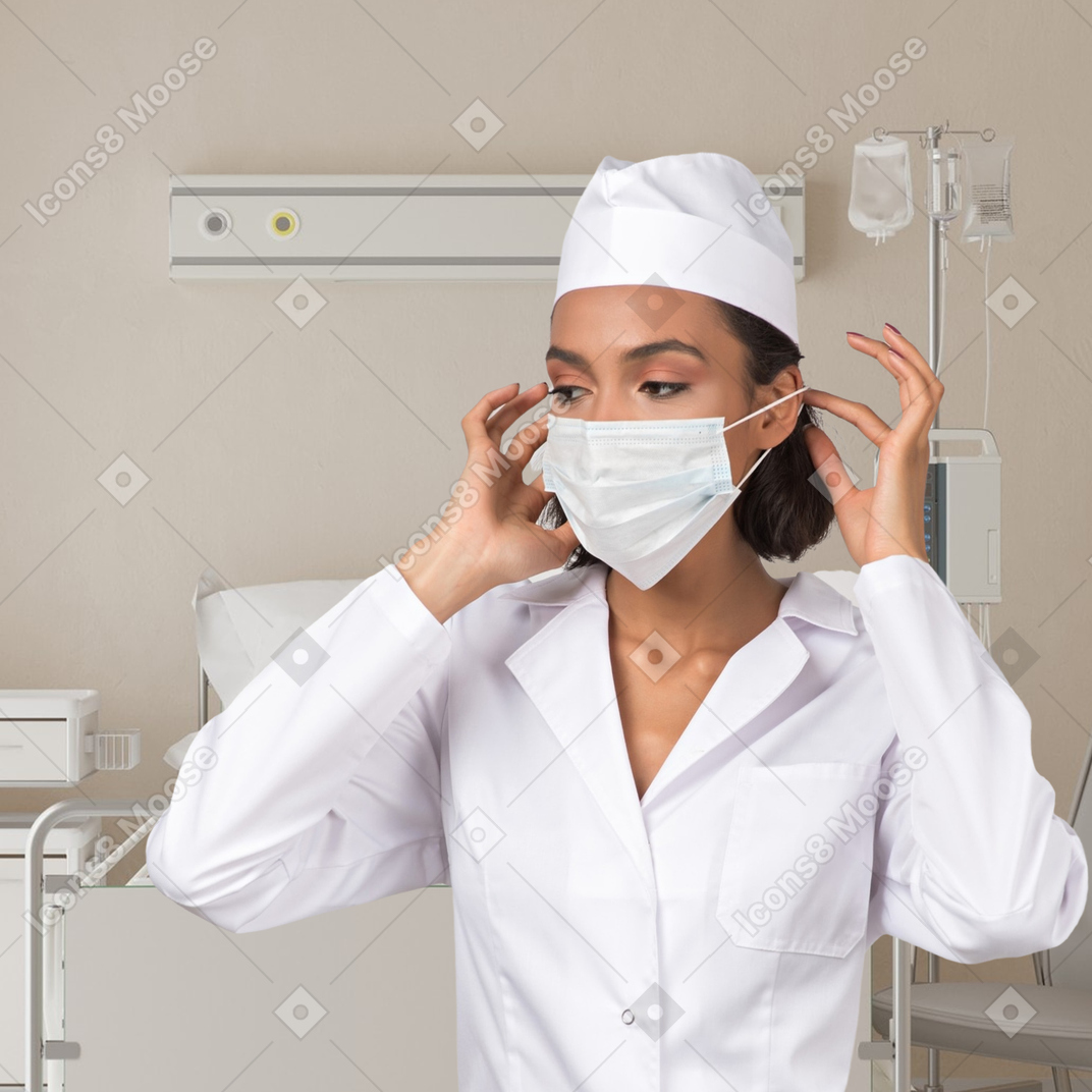 Beautiful yound doctor putting on a mask