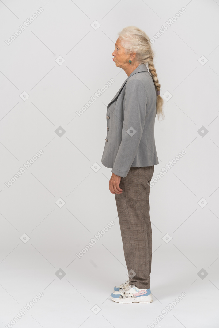 Side view of an old woman in grey jacket making faces
