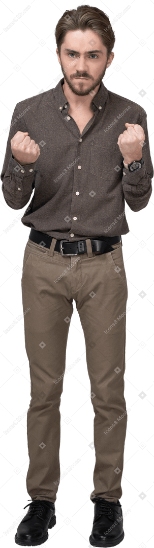 Front view of a furious man in office clothing clenching fists