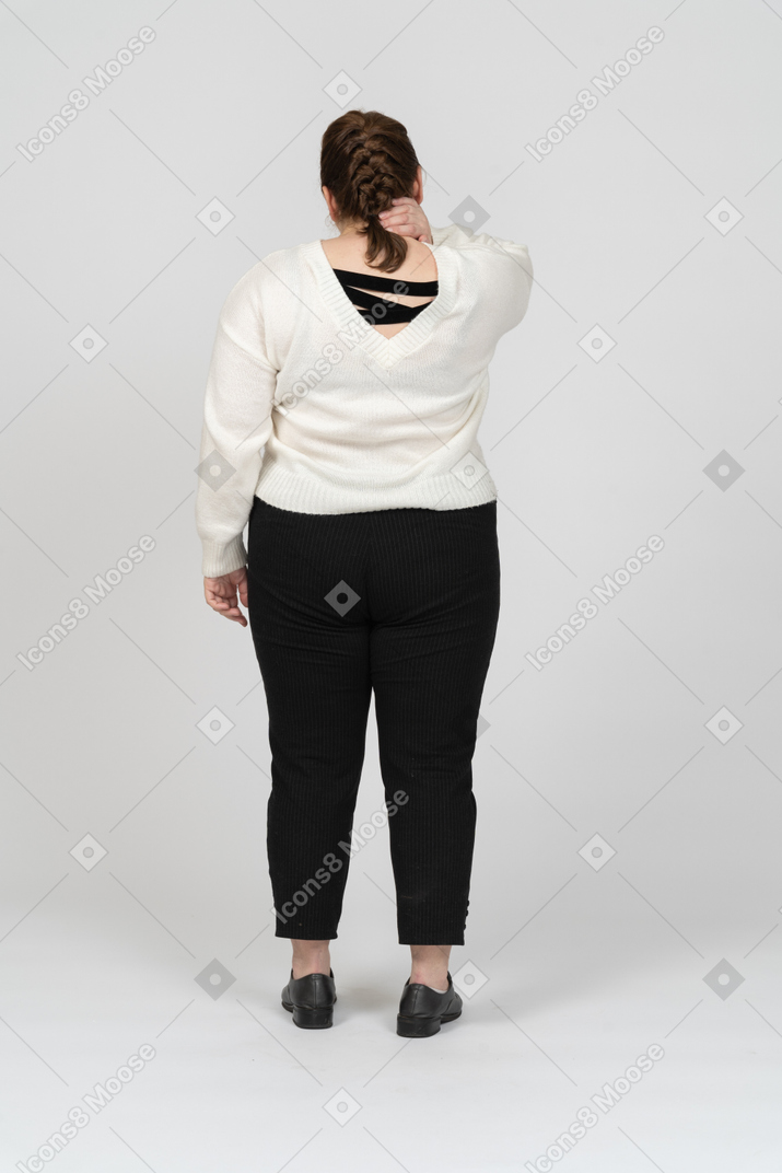Vista posteriore di una donna grassoccia che si tocca il collo