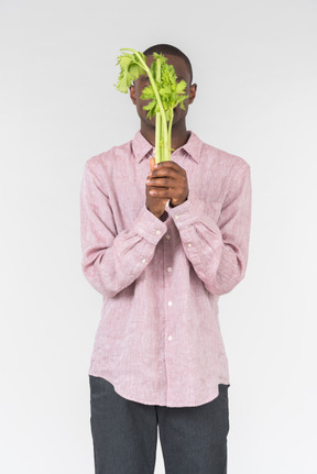 Good looking young man holding green branches