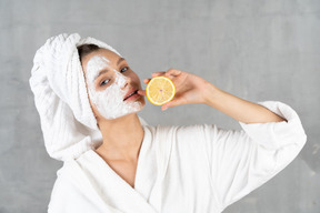 Close-up of a woman in bathrobe holding a lemon