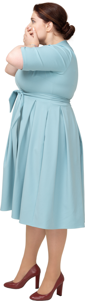 Vista lateral de uma mulher com vestido azul cobrindo a boca com as mãos