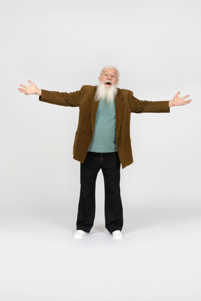 Old man standing with arms spread wide, looking amazed