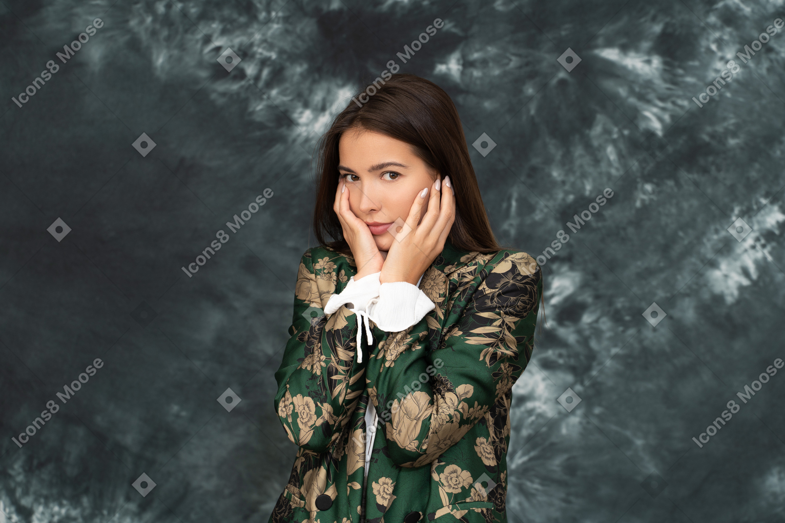 A doubtful woman in silk japanese jacket touching face with both her hands looks at camera