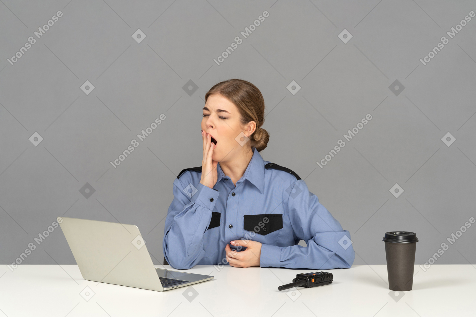Um guarda de segurança feminino sonolento bocejando em sua mesa