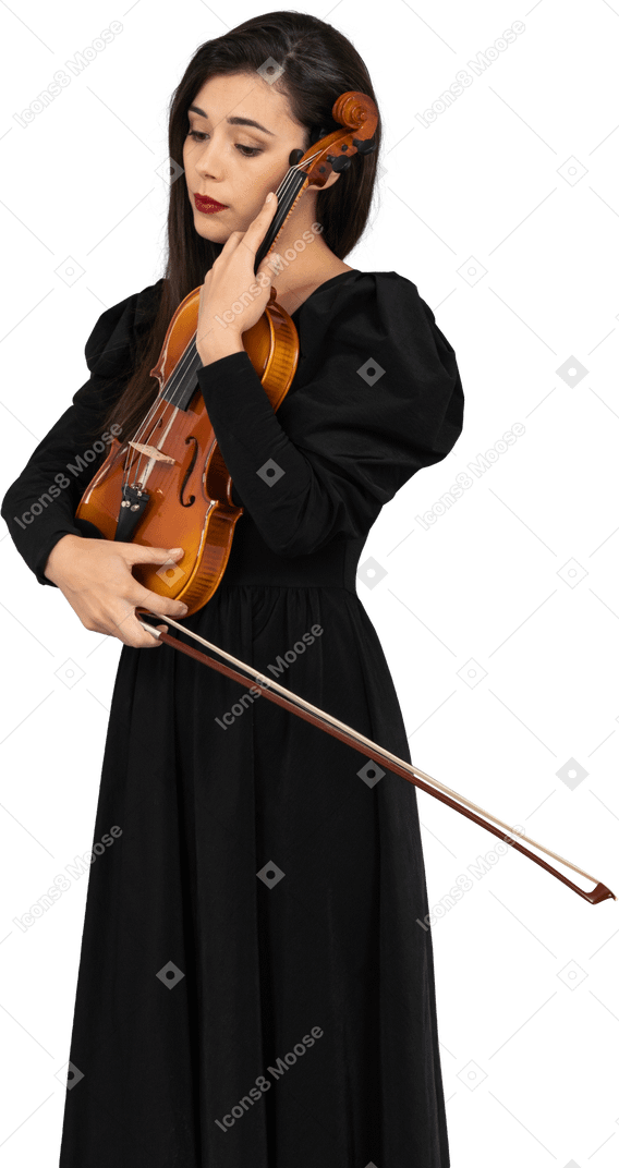Close-up de uma jovem de vestido preto abraçando seu violino