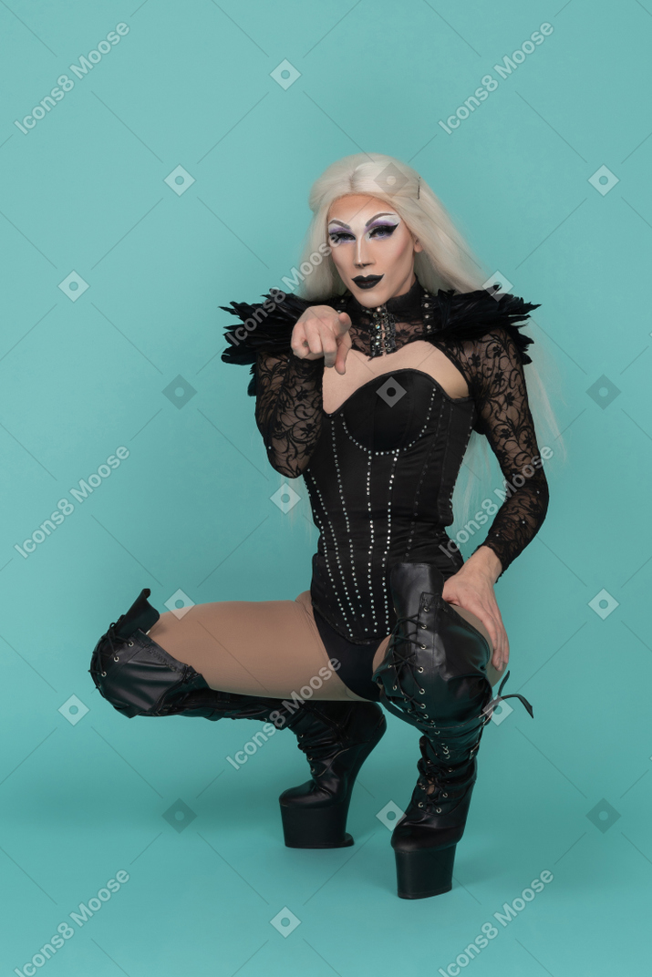 Drag queen squatted down and pointing at camera