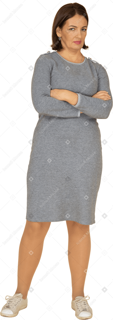 一个穿着灰色连衣裙、双臂交叉摆姿势的女人的前视图