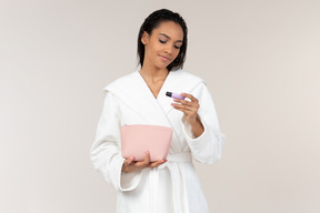 Black woman in white bathrobe going about her morning routine