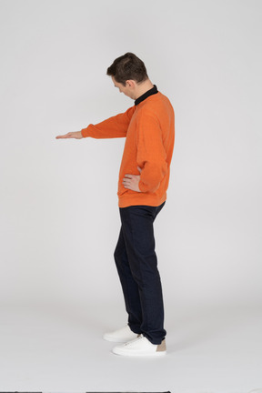Young man in orange sweatshirt standing