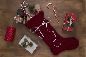 Calcetín de navidad y regalos sobre fondo de madera