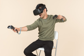 Young caucasian guy playing a virtual reality game