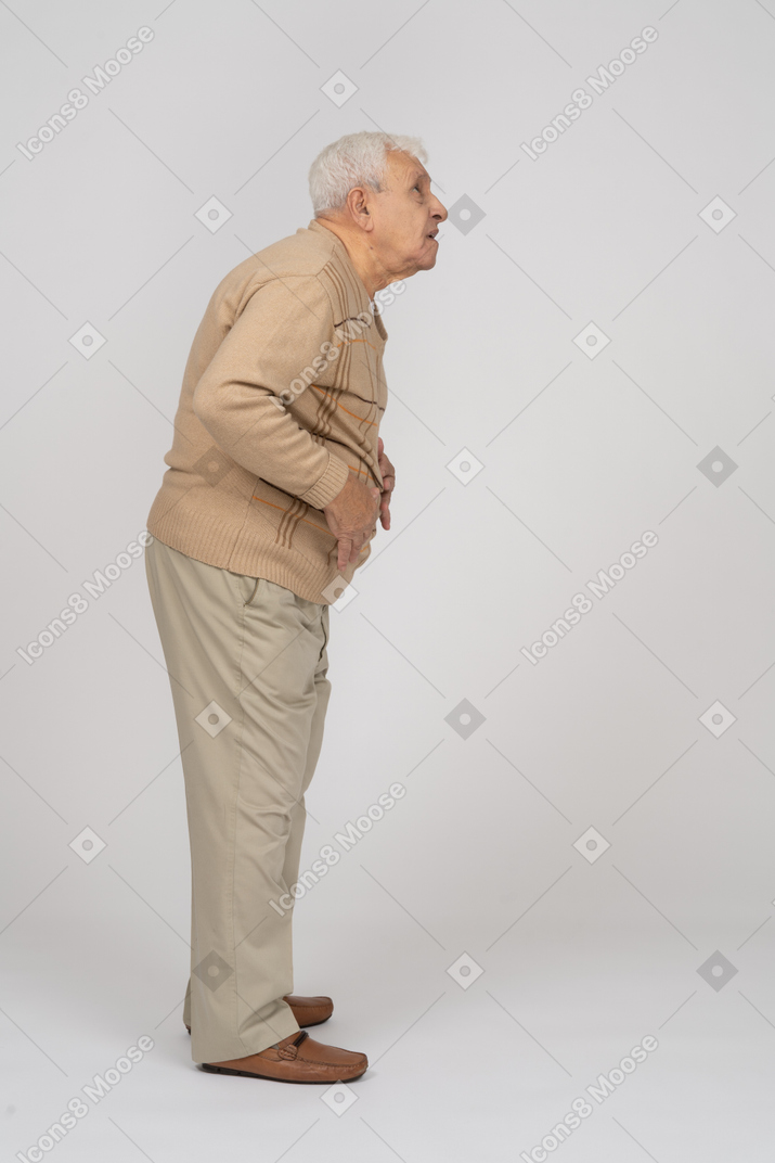 Vista lateral de un anciano impresionado mirando hacia arriba