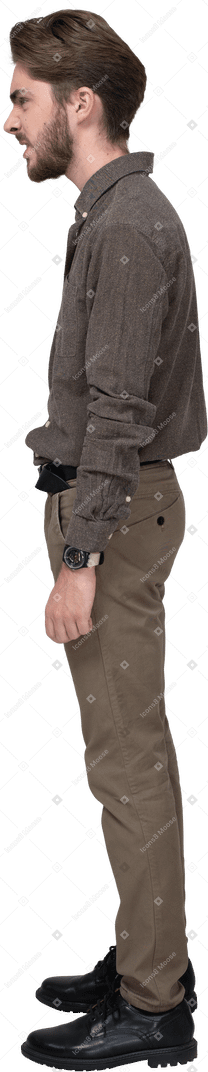 Side view of a furious man in office clothing clenching fists