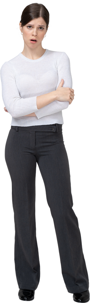 Front view of a displeased young woman in office clothing crossing hands