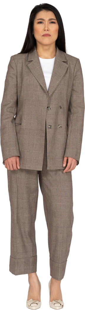 Вид спереди подозрительной барышни в коричневом деловом костюме