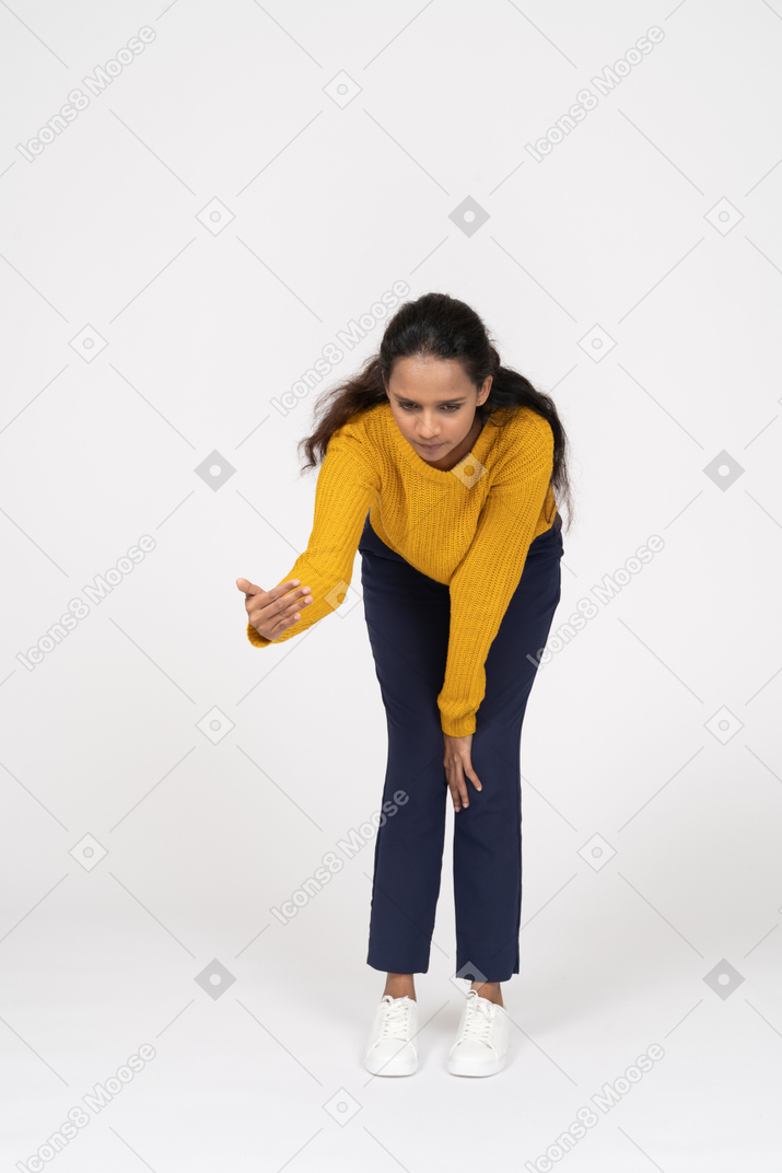 Front view of a girl in casual clothes bending down and explaining something