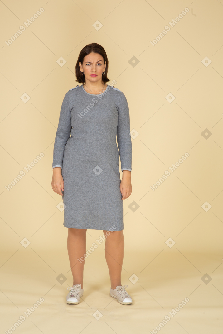 Front view of a woman in grey dress looking at camera