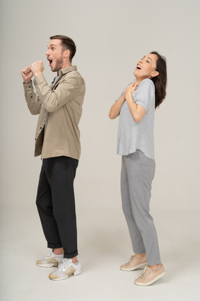 Three-quarter view of young couple cheering