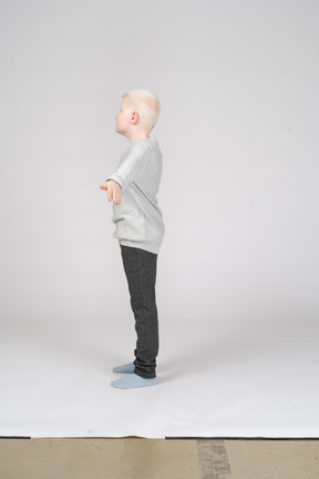 Side view of a boy with hands stretched to the side
