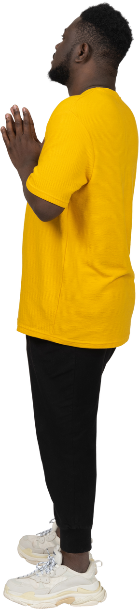 Vista lateral de un joven de piel oscura con camiseta amarilla tomados de la mano juntos
