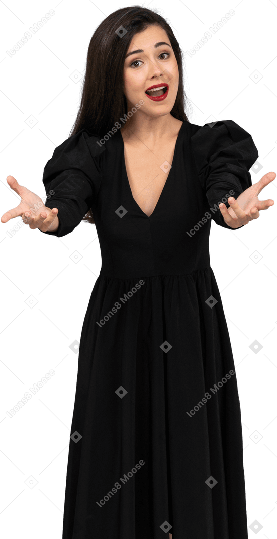 Vista frontal de uma jovem cantora em um vestido preto estendendo as mãos