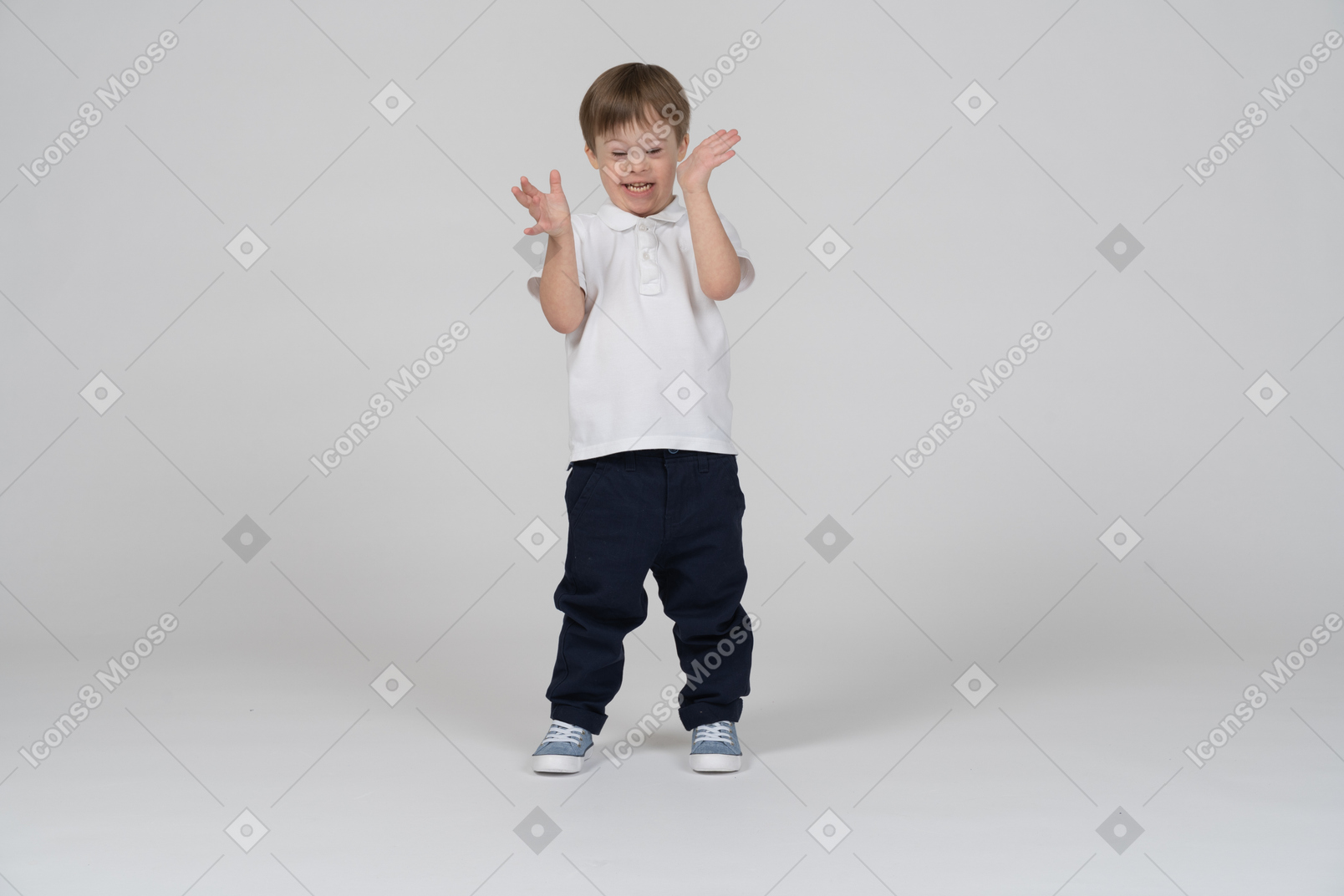 Front view of a boy smiling and gesturing excitedly with his hands