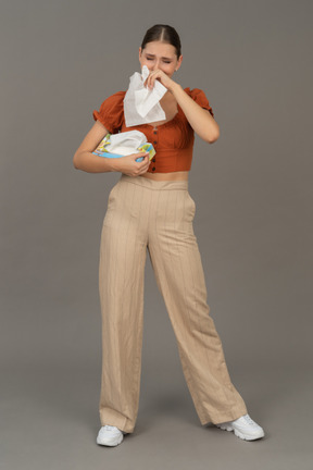 Вид спереди на молодую женщину, плачущую с салфеткой в руках