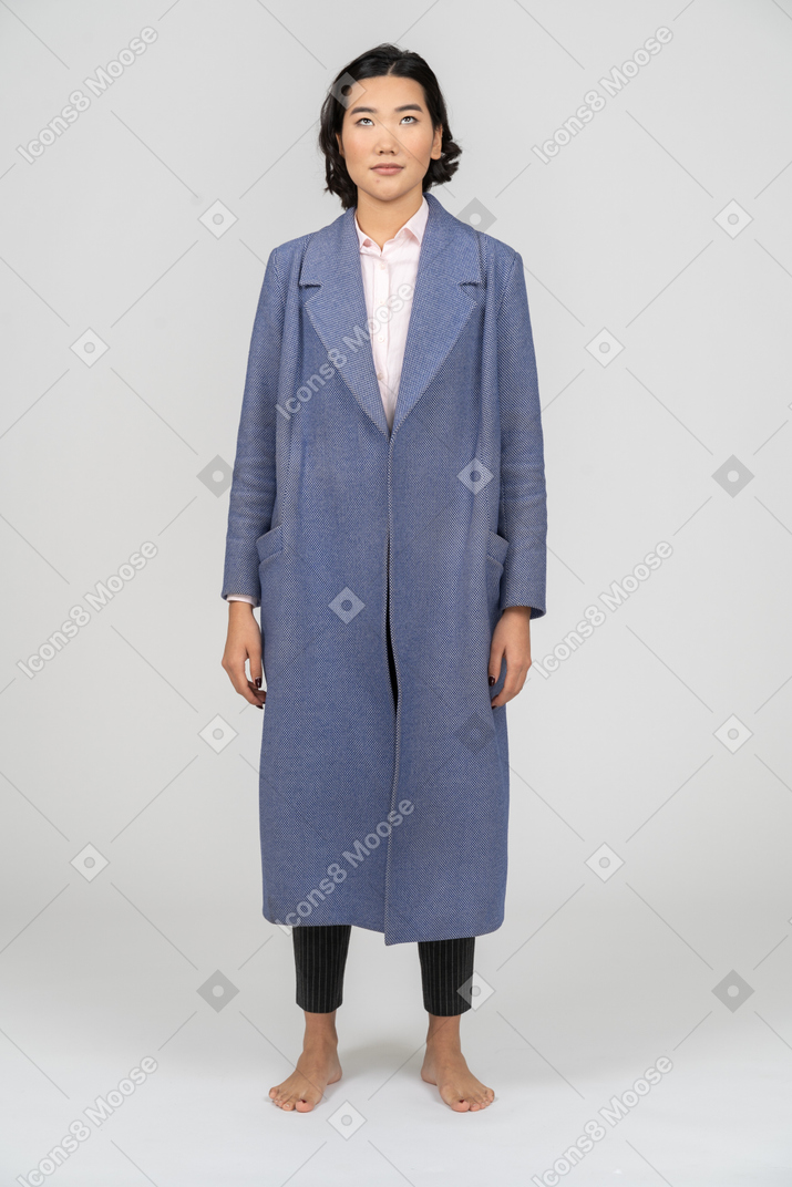 Frau im blauen mantel, die nach oben schaut