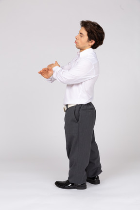 Side view of a man standing with crossed hands