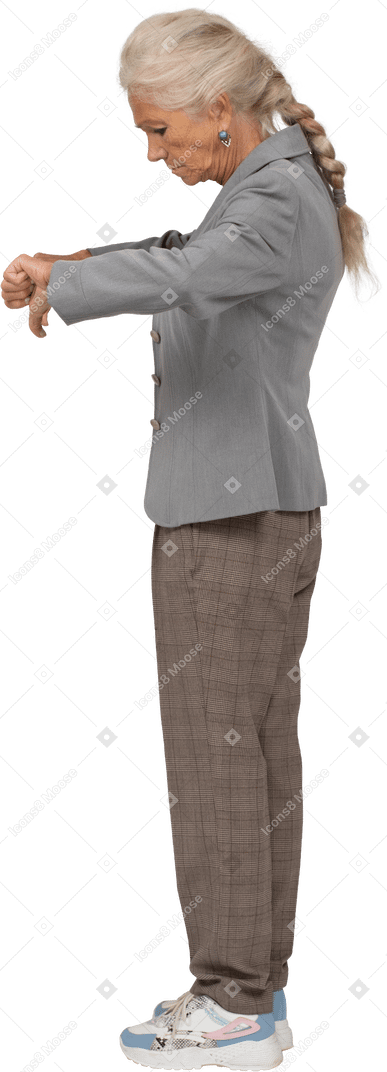 Vue latérale d'une vieille dame en costume montrant les pouces vers le bas