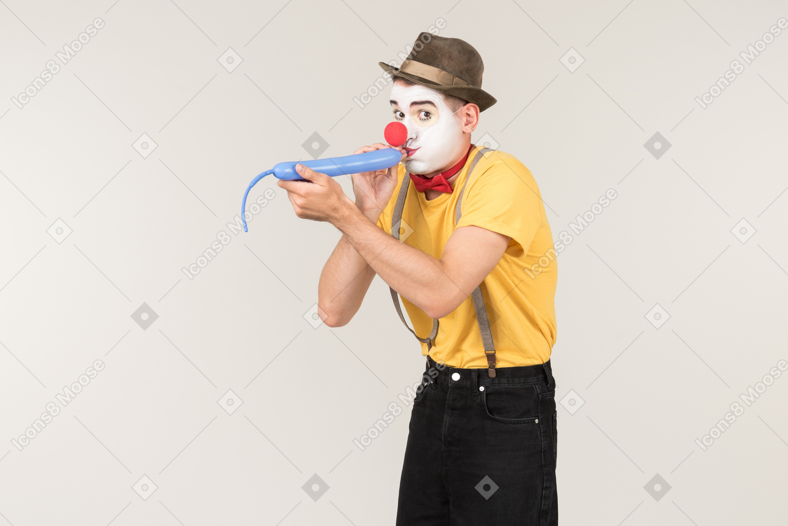 Male clown blowing blue balloon