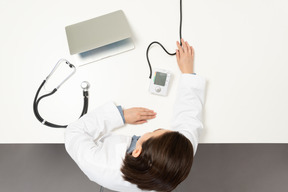 Une femme médecin en regardant un tensiomètre