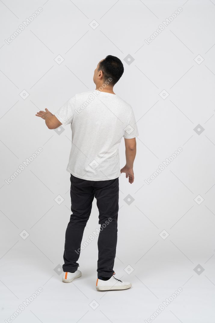 Man in casual clothes standing back to camera and looking up