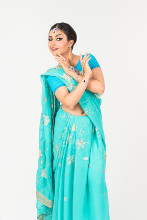 Jeune femme indienne en sari bleu debout en position de danse