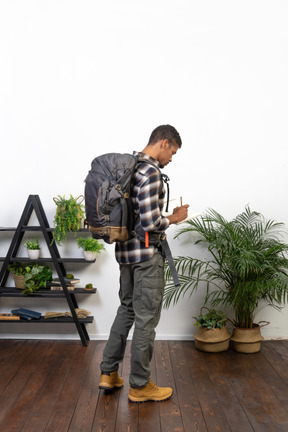 Side view of a tourist with a backpack writing down in a notepad