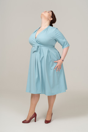 Вид спереди женщины в синем платье позирует
