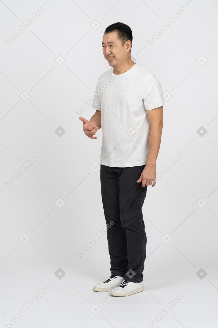 Happy man in casual clothes doing phone gesture
