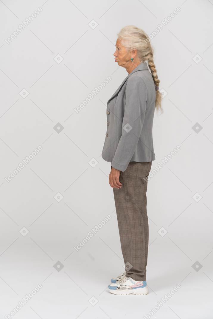 Vista laterale di una vecchia donna in giacca grigia che fa le smorfie