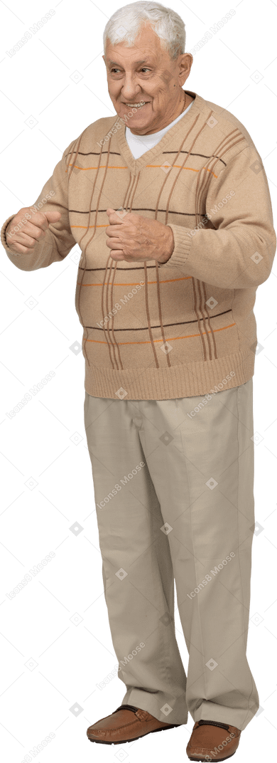 くいしばられた握りこぶしで立っているカジュアルな服を着た幸せな老人の正面図