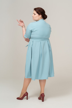 Rear view  of a woman in blue dress posing