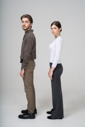 Side view of a young couple in office clothing turning head