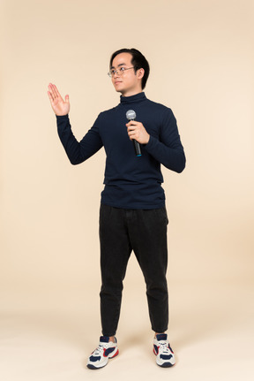 Young asian man speaking into a microphone