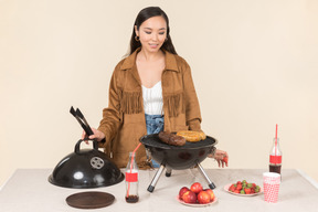 Joven mujer asiática haciendo barbacoa