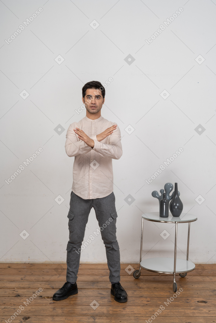 Front view of a man in casual clothes showing stop gesture