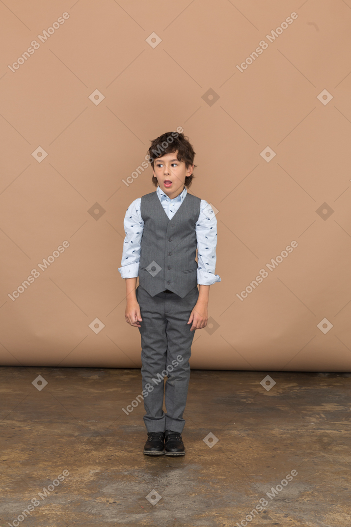 灰色のスーツを着た感動の少年の正面図
